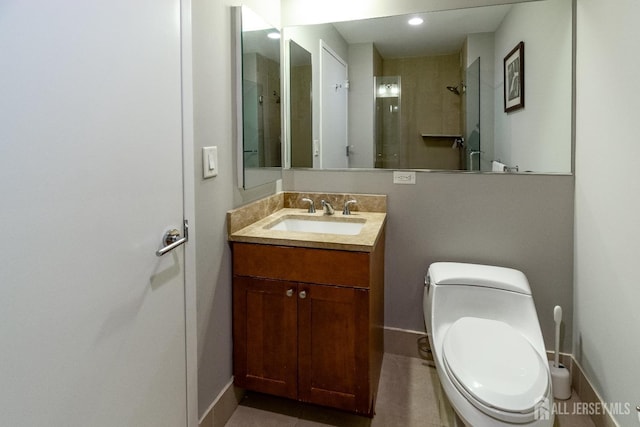 bathroom with vanity, tile patterned floors, toilet, and tiled shower