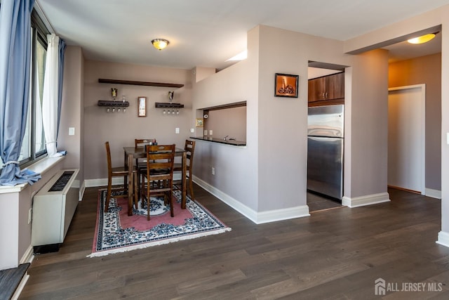 dining space featuring dark wood-type flooring and radiator