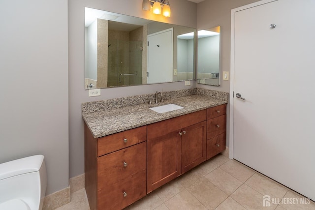 bathroom with tile patterned floors, vanity, toilet, and an enclosed shower