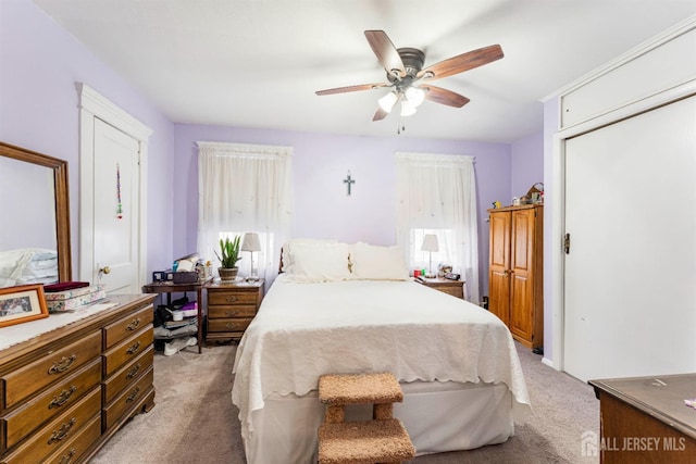 bedroom with light carpet and a ceiling fan
