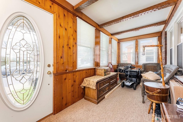 sunroom with wood walls, carpet flooring, and beamed ceiling