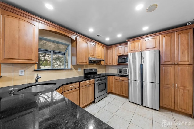 8 Carlisle Ct, Old Bridge, NJ 08857 - kitchen with appliances with stainless steel finishes, a sink, under cabinet range hood, dark stone counters, and light tile patterned floors