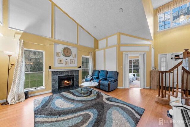 8 Carlisle Ct, Old Bridge, NJ 08857 - living area featuring high vaulted ceiling, wood finished floors, a fireplace, stairway, and baseboards