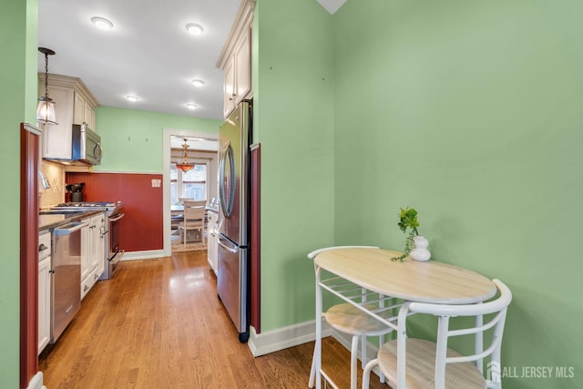 1135 Dorsey Pl, Plainfield, NJ 07062 - kitchen featuring appliances with stainless steel finishes, light wood-type flooring, decorative light fixtures, and wainscoting