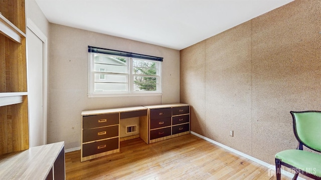 office area with baseboards and light wood-type flooring