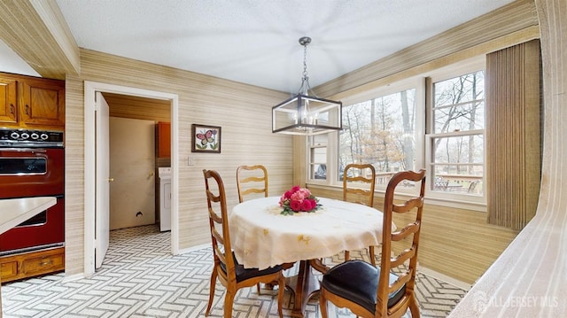 dining area featuring brick patterned floor, wallpapered walls, plenty of natural light, and a notable chandelier