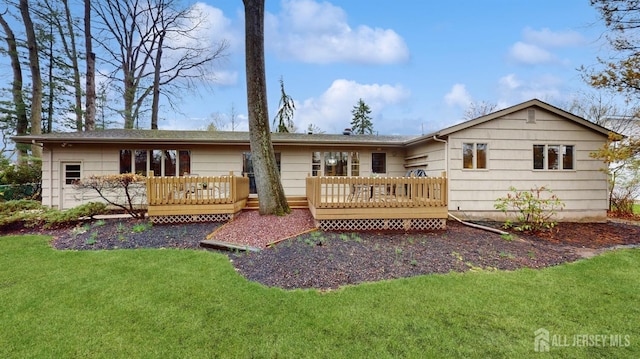back of house with a lawn and a deck
