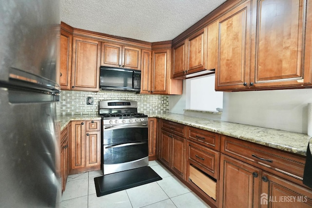 33 Rachel Ct, Franklin Twsp, NJ 08823 - kitchen with black microwave, double oven range, freestanding refrigerator, brown cabinets, and a textured ceiling