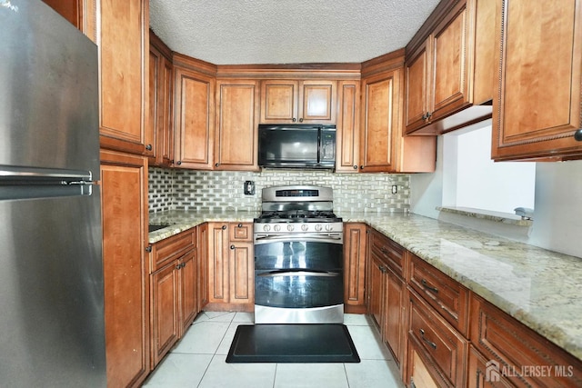 33 Rachel Ct, Franklin Twsp, NJ 08823 - kitchen with stainless steel appliances, brown cabinets, decorative backsplash, light stone counters, and light tile patterned floors