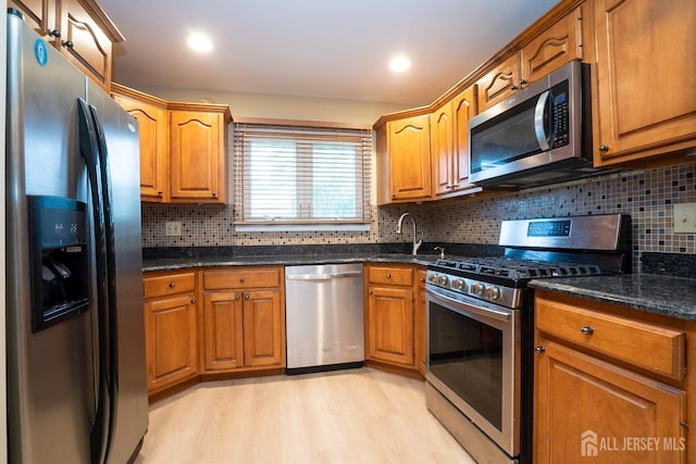 314 Benjamin Ave, Iselin, NJ 08830 - kitchen with stainless steel appliances, light wood-style floors, brown cabinets, and decorative backsplash