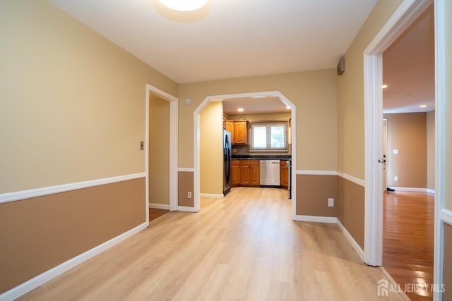 314 Benjamin Ave, Iselin, NJ 08830 - kitchen with dishwasher, black refrigerator with ice dispenser, light wood finished floors, arched walkways, and brown cabinets