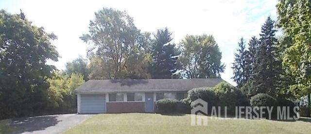 ranch-style house featuring a front lawn and a garage