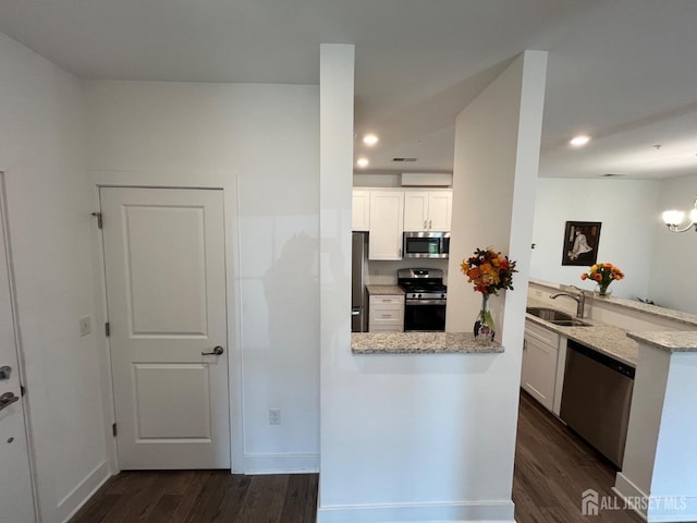 812 Stiller Ln, Monroe, NJ 08831 - kitchen with stainless steel appliances, a peninsula, a sink, dark wood-style flooring, and white cabinetry