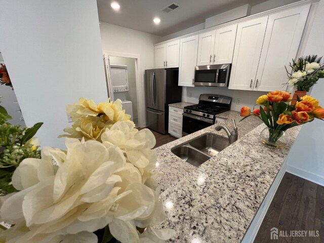 812 Stiller Ln, Monroe, NJ 08831 - kitchen with appliances with stainless steel finishes, a sink, light stone counters, white cabinets, and dark wood-style floors