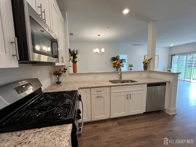812 Stiller Ln, Monroe, NJ 08831 - kitchen with appliances with stainless steel finishes, a sink, dark wood finished floors, light stone counters, and white cabinetry