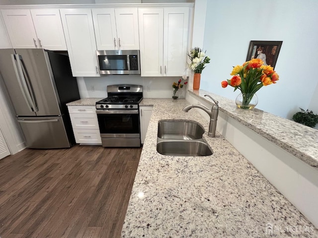 812 Stiller Ln, Monroe, NJ 08831 - kitchen featuring stainless steel appliances, a sink, white cabinets, light stone counters, and dark wood-style floors