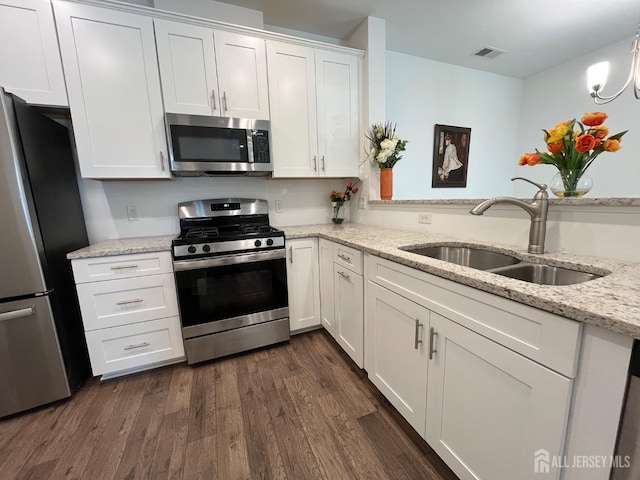 812 Stiller Ln, Monroe, NJ 08831 - kitchen featuring appliances with stainless steel finishes, a sink, white cabinets, dark wood finished floors, and light stone counters