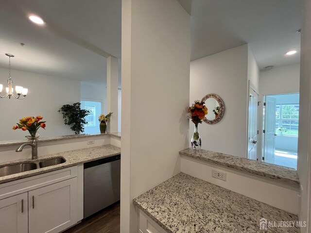 812 Stiller Ln, Monroe, NJ 08831 - kitchen with stainless steel dishwasher, a sink, light stone countertops, decorative light fixtures, and dark wood-type flooring