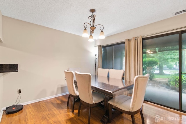 320 Willowbrook Dr, North Brunswick, NJ 08902 - dining area featuring a chandelier, wood finished floors, and a textured ceiling