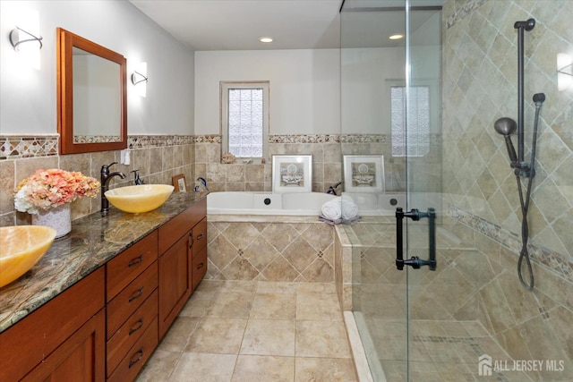 75 Brown Rd, Howell, NJ 07731 - bathroom with double vanity, a bath, a shower stall, tile walls, and tile patterned flooring