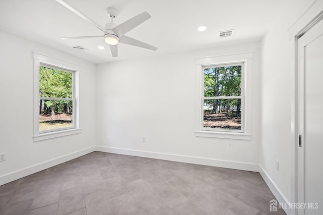 empty room with ceiling fan and a healthy amount of sunlight