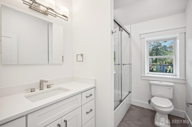 full bathroom with tile patterned floors, vanity, enclosed tub / shower combo, and toilet