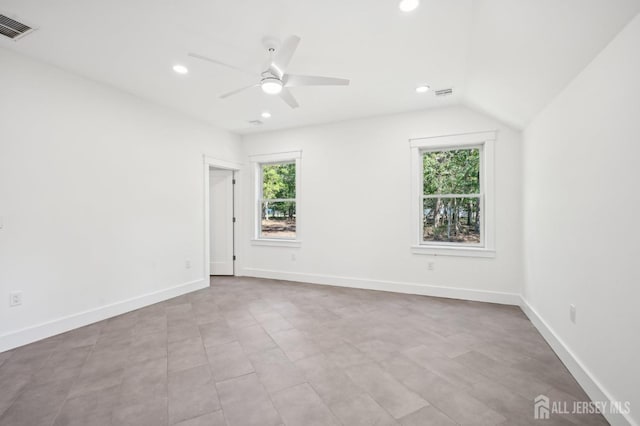 spare room with vaulted ceiling, a wealth of natural light, and ceiling fan