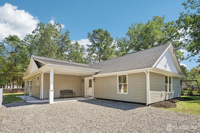 view of front facade featuring a patio and roof with shingles