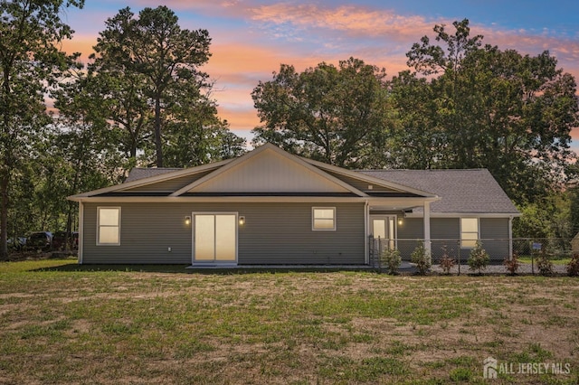 view of front of property featuring fence and a yard