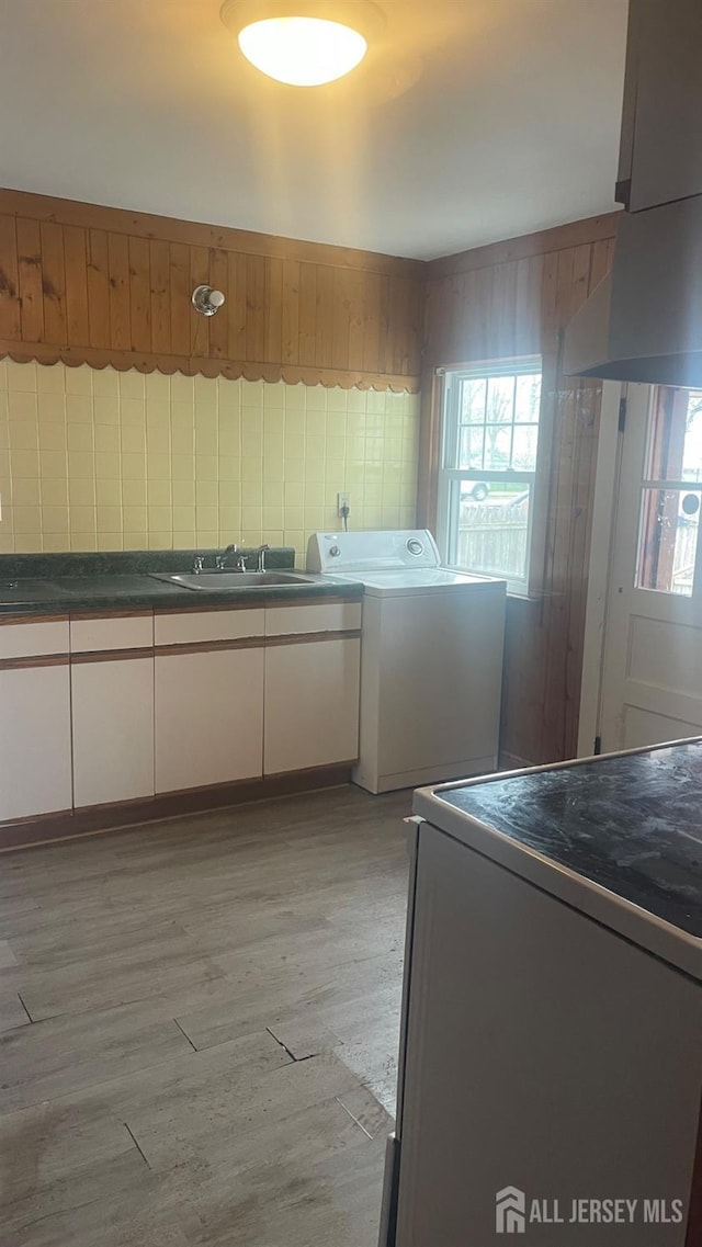 144 Inman Ave, Colonia, NJ 07067 - kitchen with washer / clothes dryer, a sink, light wood finished floors, and dark countertops