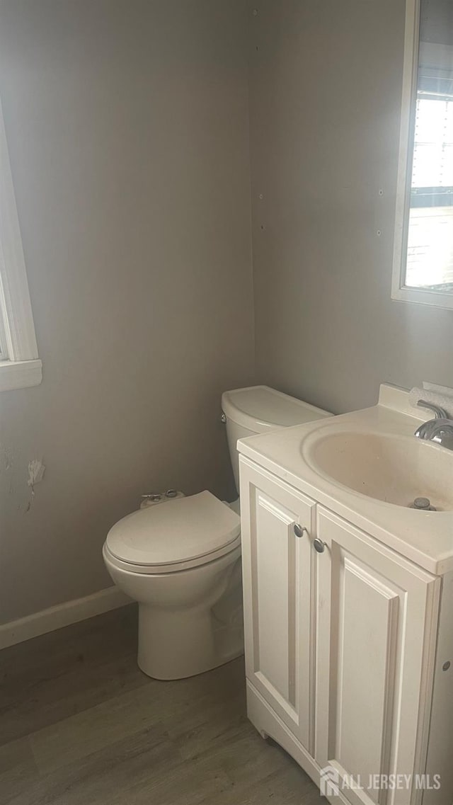 144 Inman Ave, Colonia, NJ 07067 - half bathroom with vanity, toilet, wood finished floors, and baseboards
