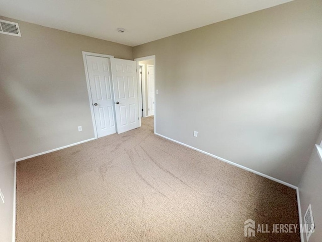 unfurnished bedroom featuring visible vents, baseboards, and carpet floors