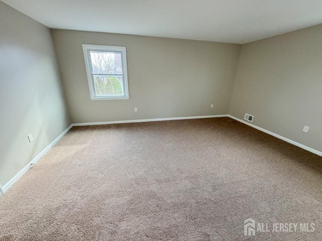 unfurnished room featuring baseboards, carpet, and visible vents