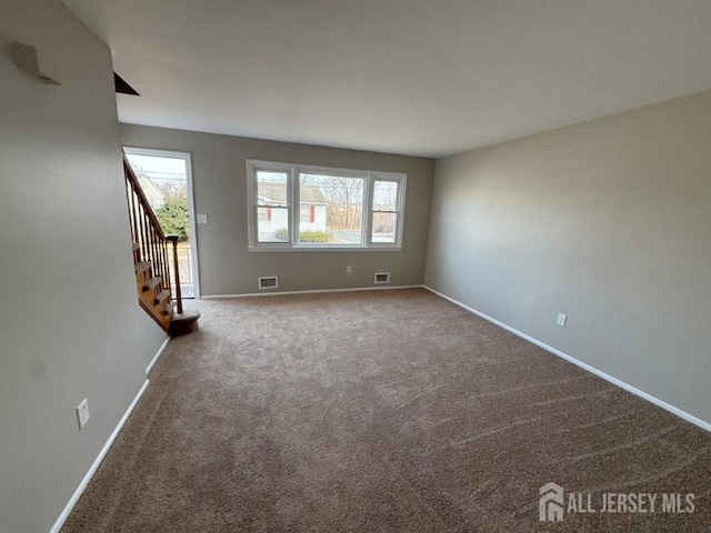 spare room with stairs, visible vents, baseboards, and carpet floors