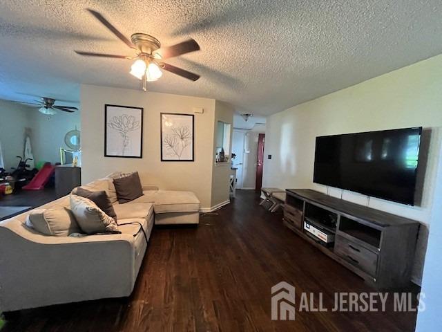 living room with dark wood-type flooring and a textured ceiling