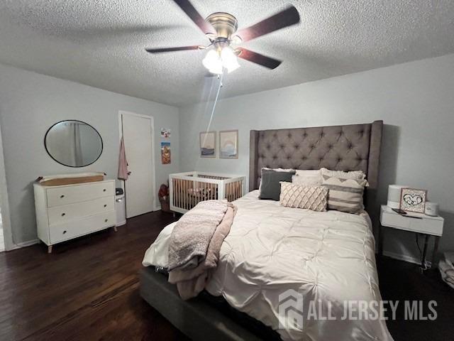 bedroom with ceiling fan, a textured ceiling, and wood finished floors