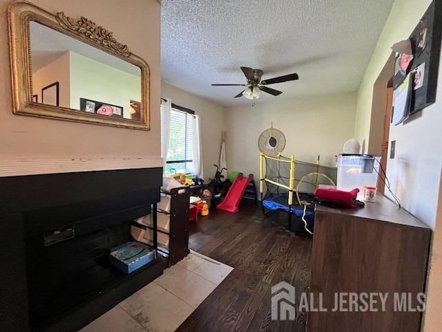 bedroom featuring ceiling fan, a textured ceiling, and wood finished floors