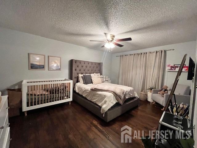 bedroom with a ceiling fan, wood finished floors, and a textured ceiling