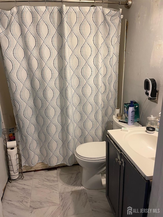 full bath with toilet, marble finish floor, a shower with curtain, and vanity