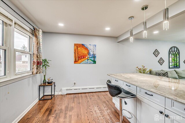 laundry area with a baseboard radiator, recessed lighting, baseboards, and wood finished floors