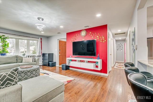 living area featuring light wood-style flooring, visible vents, and recessed lighting