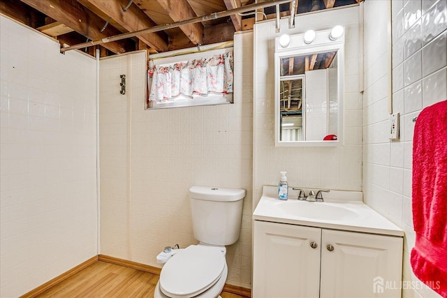 full bathroom with a tile shower, vanity, toilet, and wood finished floors