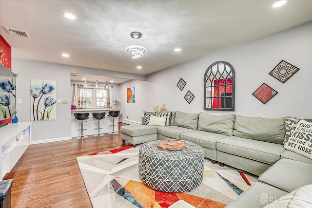 living area with baseboards, visible vents, wood finished floors, and recessed lighting