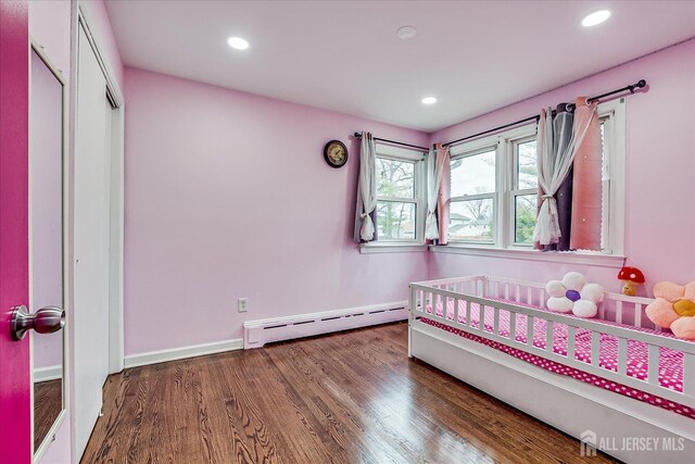 bedroom with baseboards, baseboard heating, wood finished floors, and recessed lighting