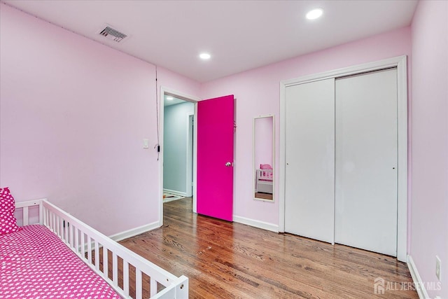 bedroom featuring baseboards, visible vents, wood finished floors, a closet, and recessed lighting