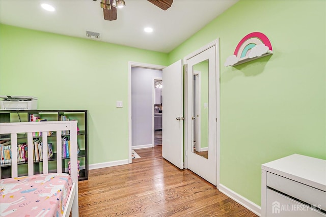 bedroom with recessed lighting, wood finished floors, visible vents, and baseboards