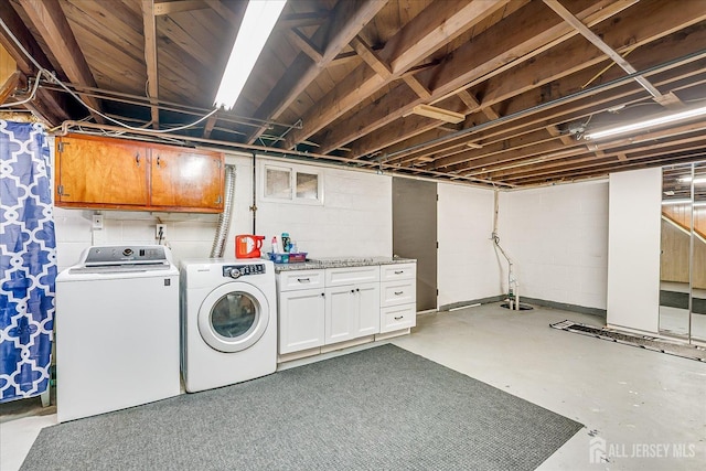 washroom featuring cabinet space and independent washer and dryer