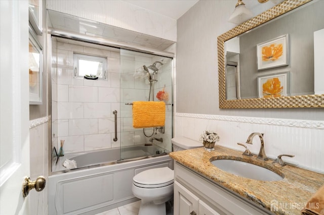 full bathroom with enclosed tub / shower combo, vanity, and toilet