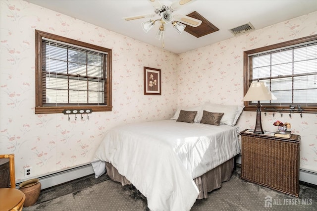 carpeted bedroom with ceiling fan and baseboard heating