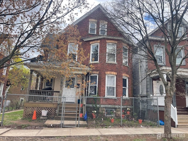 290 Redmond St, New Brunswick, NJ 08901 - view of front of property featuring covered porch, a fenced front yard, and brick siding